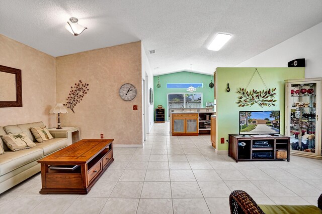8066 Stirrup Cay Ct, Boynton Beach, FL 33436 - living room with vaulted ceiling, a textured ceiling, light tile patterned floors, and baseboards