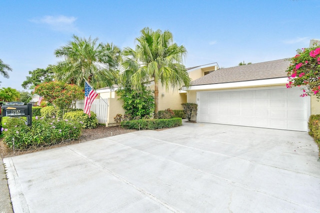 17187 Bay St, Jupiter, FL 33477 - view of front of house featuring concrete driveway, a garage, and stucco siding