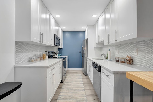 10164 40th Way S Unit 256, Boynton Beach, FL 33436 - kitchen featuring appliances with stainless steel finishes, light countertops, backsplash, light wood-type flooring, and recessed lighting