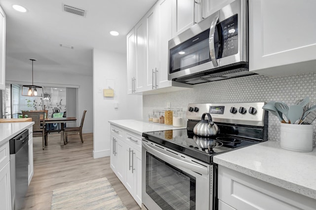 10164 40th Way S Unit 256, Boynton Beach, FL 33436 - kitchen with stainless steel appliances, white cabinets, light wood-type flooring, tasteful backsplash, and light stone counters