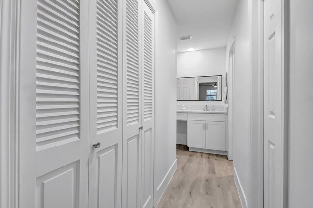 10164 40th Way S Unit 256, Boynton Beach, FL 33436 - hallway featuring light wood-type flooring, baseboards, and a sink