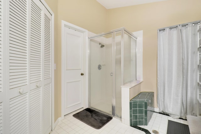 full bathroom with a closet, a shower stall, and tile patterned floors
