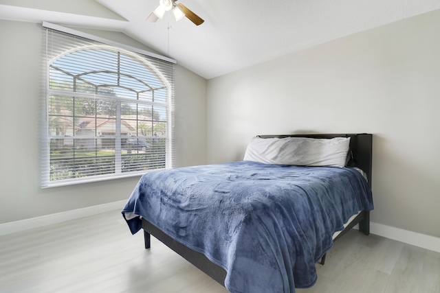 bedroom featuring baseboards, wood finished floors, lofted ceiling, and ceiling fan