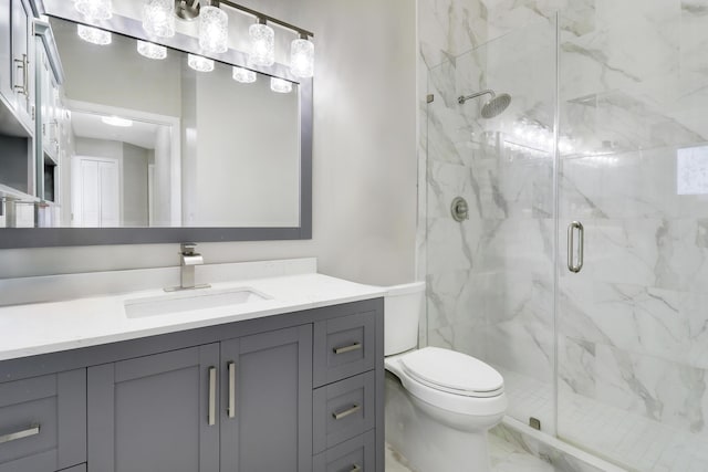 bathroom with toilet, a marble finish shower, marble finish floors, and vanity