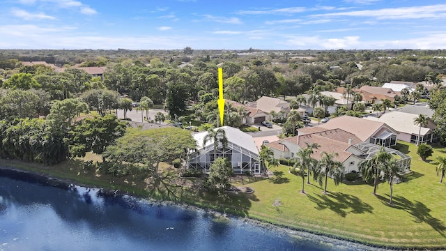 aerial perspective of suburban area featuring a large body of water and a tree filled landscape