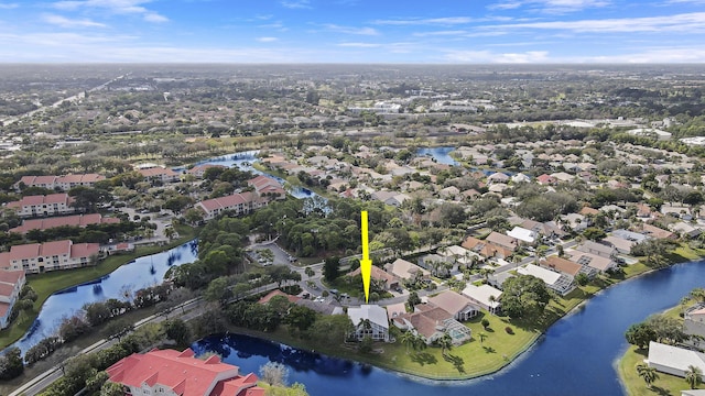 aerial view of property and surrounding area featuring a nearby body of water and nearby suburban area