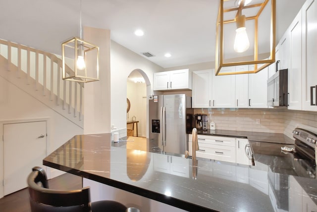 4838 Palmbrooke Cir, West Palm Beach, FL 33417 - kitchen featuring stainless steel appliances, arched walkways, backsplash, pendant lighting, and white cabinetry