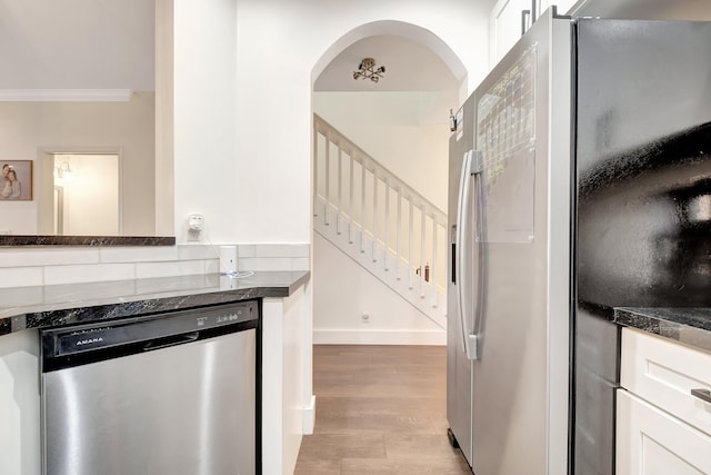 4838 Palmbrooke Cir, West Palm Beach, FL 33417 - kitchen with stainless steel appliances, light wood-type flooring, white cabinets, crown molding, and arched walkways