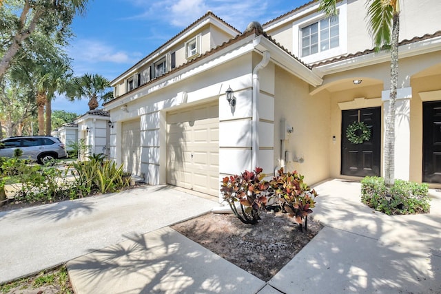 4838 Palmbrooke Cir, West Palm Beach, FL 33417 - view of front of home with stucco siding, concrete driveway, a tiled roof, and a garage