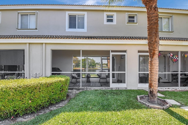 4838 Palmbrooke Cir, West Palm Beach, FL 33417 - back of house featuring a sunroom, a yard, a tiled roof, and stucco siding
