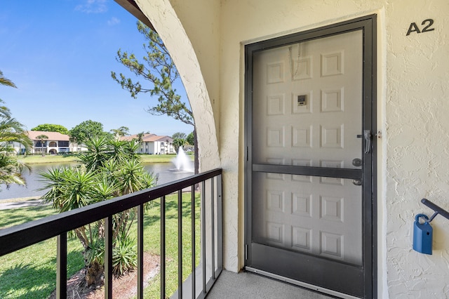 3561 Pine Tree Ct Unit A-2, Greenacres, FL 33463 - view of exterior entry featuring stucco siding, a water view, and a balcony