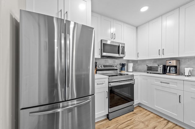 3561 Pine Tree Ct Unit A-2, Greenacres, FL 33463 - kitchen featuring appliances with stainless steel finishes, light countertops, white cabinets, recessed lighting, and decorative backsplash