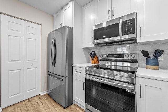 3561 Pine Tree Ct Unit A-2, Greenacres, FL 33463 - kitchen featuring appliances with stainless steel finishes, light countertops, white cabinetry, and light wood-type flooring