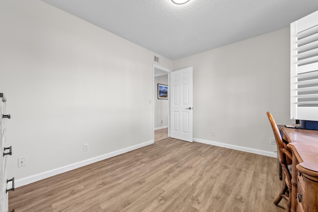 3561 Pine Tree Ct Unit A-2, Greenacres, FL 33463 - unfurnished office with light wood finished floors, baseboards, and a textured ceiling