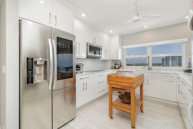 400 Seasage Dr Unit 805, Delray Beach, FL 33483 - kitchen with stainless steel appliances, a sink, decorative backsplash, white cabinetry, and light countertops