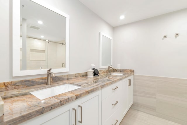 400 Seasage Dr Unit 805, Delray Beach, FL 33483 - bathroom featuring double vanity, an enclosed shower, recessed lighting, tile walls, and a wainscoted wall