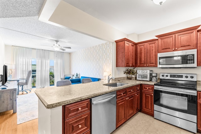 55 SW 2nd Ave Unit 405G, Boca Raton, FL 33432 - kitchen featuring stainless steel appliances, wallpapered walls, a sink, open floor plan, and a peninsula