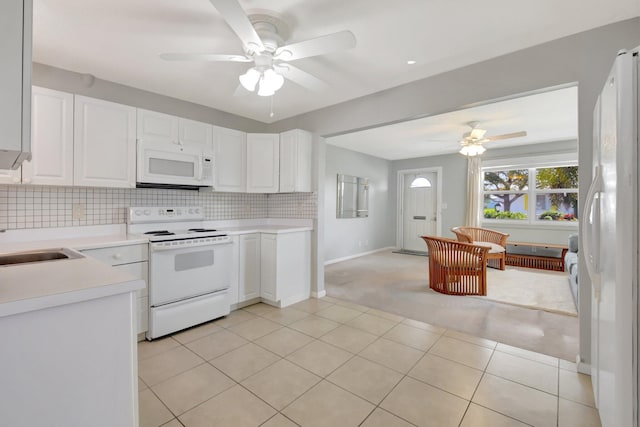 kitchen featuring white appliances, a ceiling fan, light countertops, light colored carpet, and white cabinetry