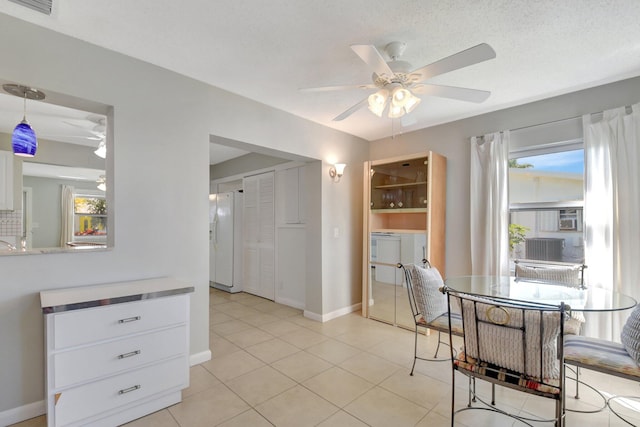 dining area with a ceiling fan, light tile patterned flooring, and baseboards