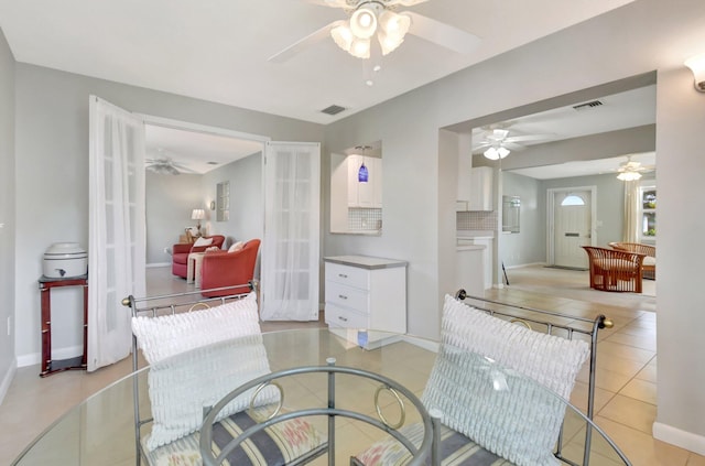 dining space featuring ceiling fan, light tile patterned floors, and baseboards