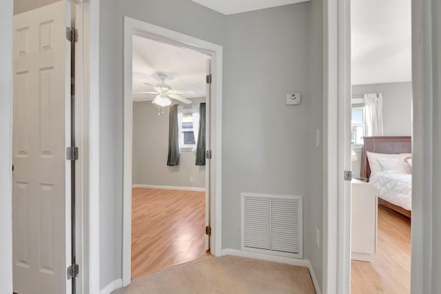 hall with baseboards and light wood-style floors