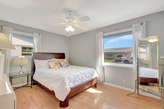 bedroom featuring wood finished floors, baseboards, and ceiling fan