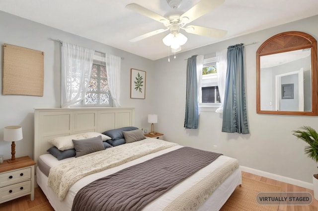 bedroom featuring wood finished floors, baseboards, and ceiling fan