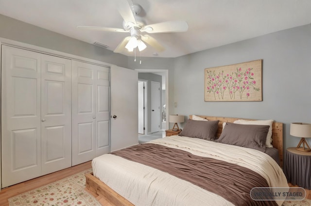 bedroom with light wood-type flooring, a closet, and a ceiling fan