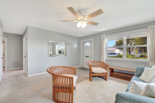 living room with light carpet, baseboards, and ceiling fan