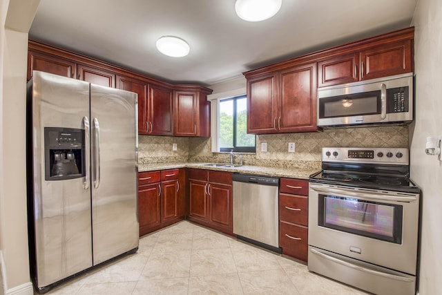 50 SE 12th St Unit 2640, Boca Raton, FL 33432 - kitchen with stainless steel appliances, a sink, reddish brown cabinets, tasteful backsplash, and light stone countertops