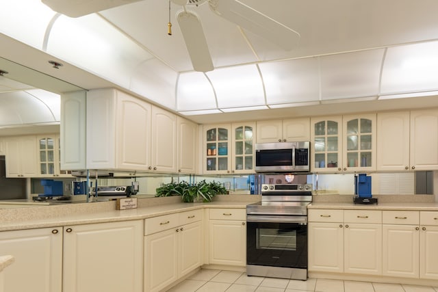 kitchen with appliances with stainless steel finishes, light tile patterned floors, and light countertops