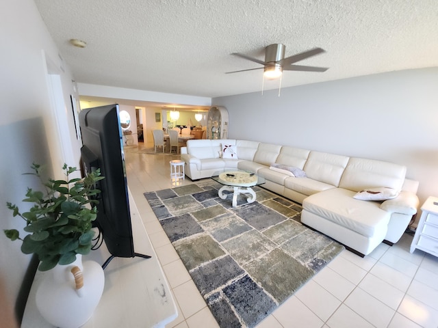 tiled living room with a textured ceiling and ceiling fan