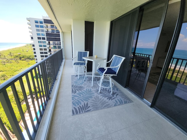 balcony with view of water and beach