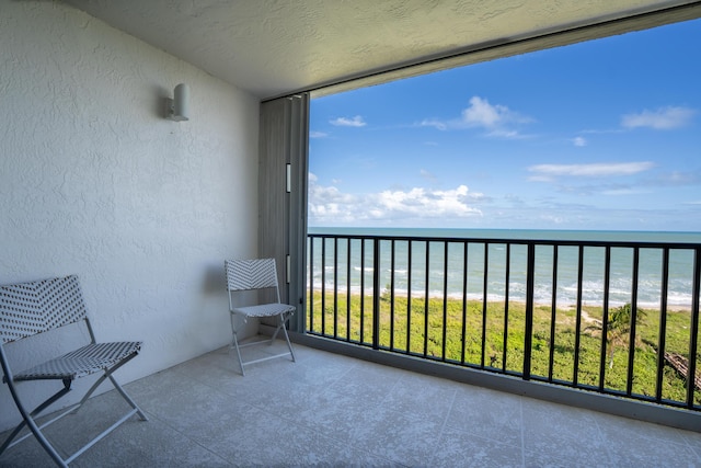 balcony with view of water and beach