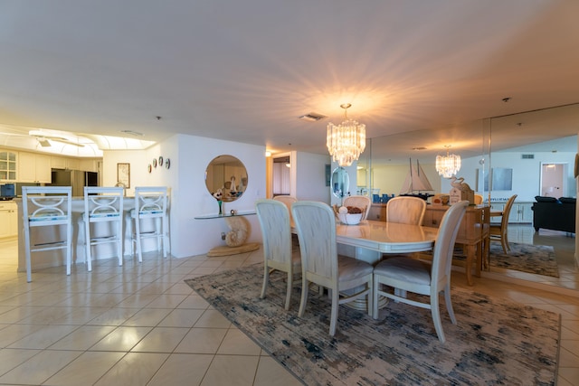 dining area featuring a chandelier and light tile patterned flooring