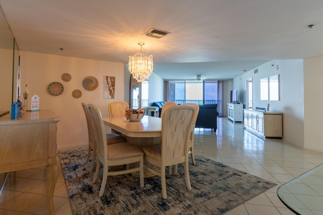 dining space with a chandelier, light tile patterned flooring, and baseboards