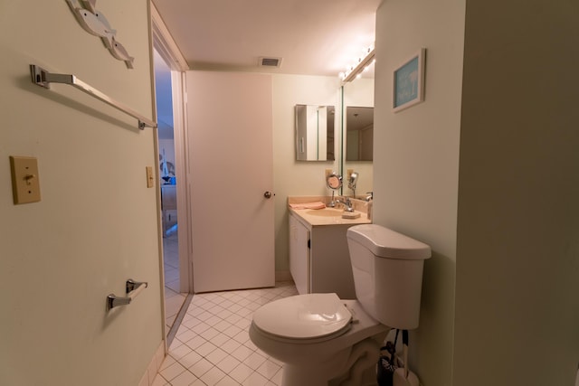 bathroom with toilet, tile patterned flooring, and vanity
