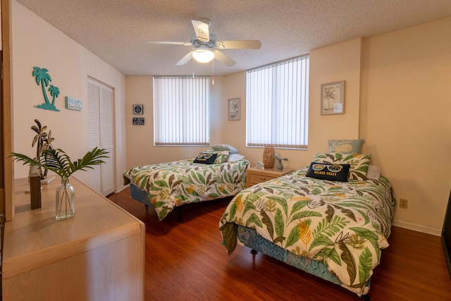 bedroom featuring wood finished floors, a textured ceiling, ceiling fan, baseboards, and a closet