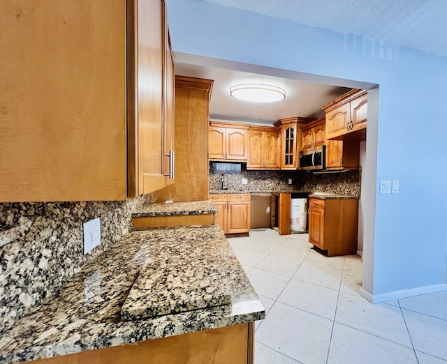 210 Somerset K, West Palm Beach, FL 33417 - kitchen featuring stainless steel appliances, decorative backsplash, glass insert cabinets, and light tile patterned floors