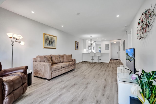 living room with a chandelier, light wood-style floors, recessed lighting, and baseboards