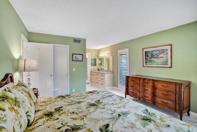 bedroom featuring connected bathroom and baseboards