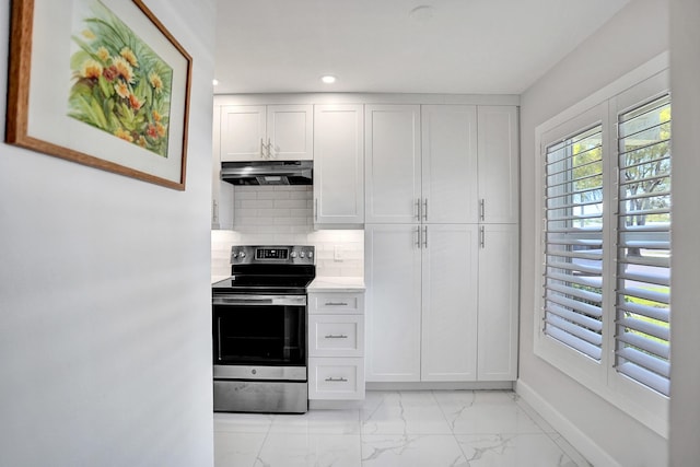 kitchen featuring stainless steel electric stove, under cabinet range hood, light marble finish floors, tasteful backsplash, and light countertops