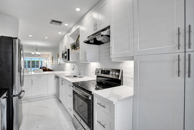 kitchen featuring stainless steel appliances, a sink, under cabinet range hood, recessed lighting, and light marble finish flooring