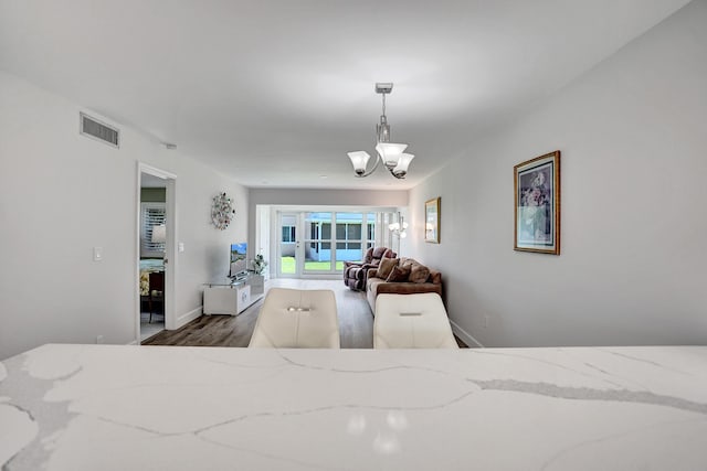 bedroom featuring wood finished floors, a chandelier, and baseboards