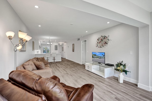 living room featuring wood finished floors, recessed lighting, baseboards, and a chandelier