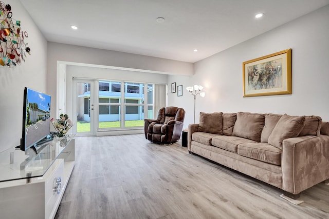 living area with light wood-type flooring and recessed lighting