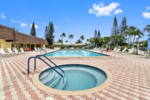 community pool with a hot tub and a patio