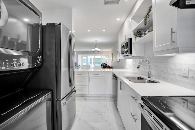 kitchen featuring a sink, stainless steel appliances, light marble finish floors, white cabinets, and recessed lighting