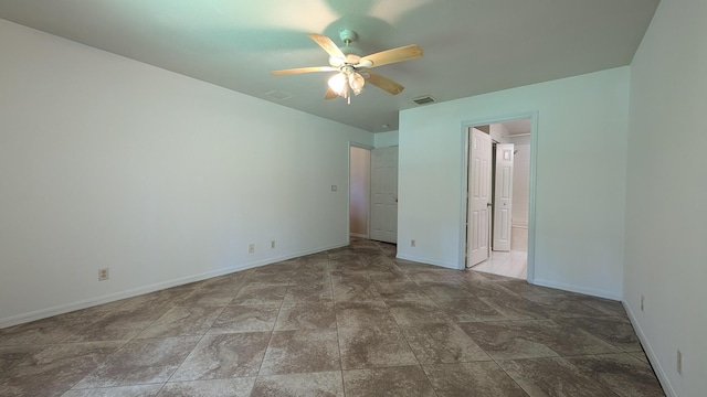 1500 SW Bermel Ave, Port Saint Lucie, FL 34953 - unfurnished bedroom featuring baseboards, stone finish flooring, ceiling fan, and ensuite bathroom