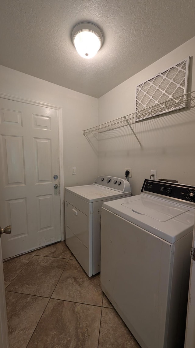 1500 SW Bermel Ave, Port Saint Lucie, FL 34953 - laundry area with washing machine and clothes dryer, light tile patterned floors, and a textured ceiling